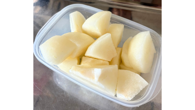 今年初めて味わう梨をカットして保存容器に入れた写真。みずみずしい果肉が光り、旬の果物の美味しさを感じさせる。